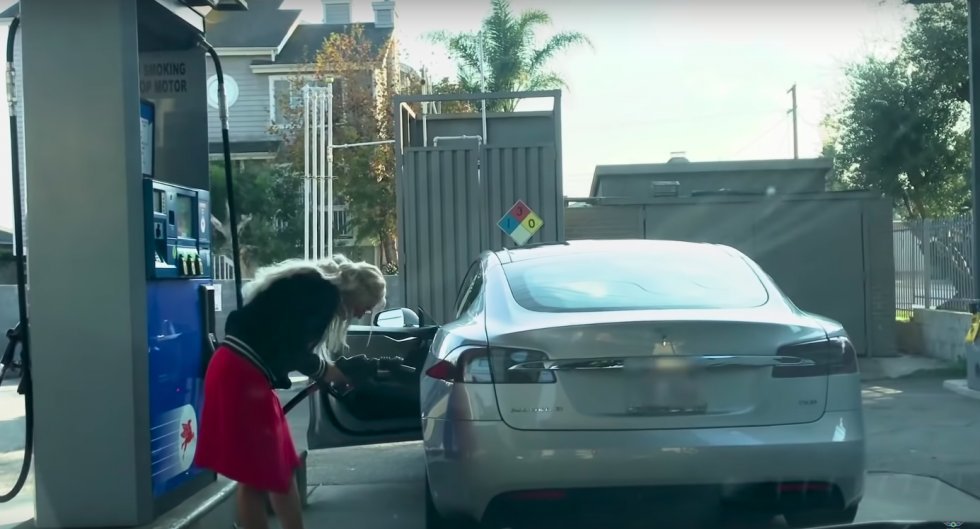 Blondine forsøger at fylde benzin på en Tesla