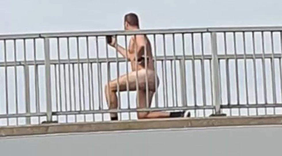Mand spottet på motorvejsbro, mens han laver squats nøgen