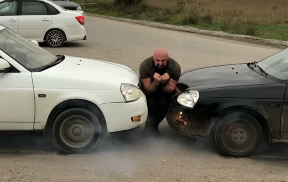 Den russiske The Rock viser muskler ved at kile sig mellem to kørende biler