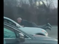 Årets vildeste roadrage: Mand hænger på kølerhjelmen af en bil på motorvejen