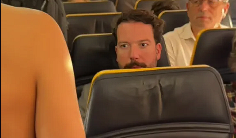 Kvinde overrasker flypassagerer med vovet outfit: Se når hun vender sig om